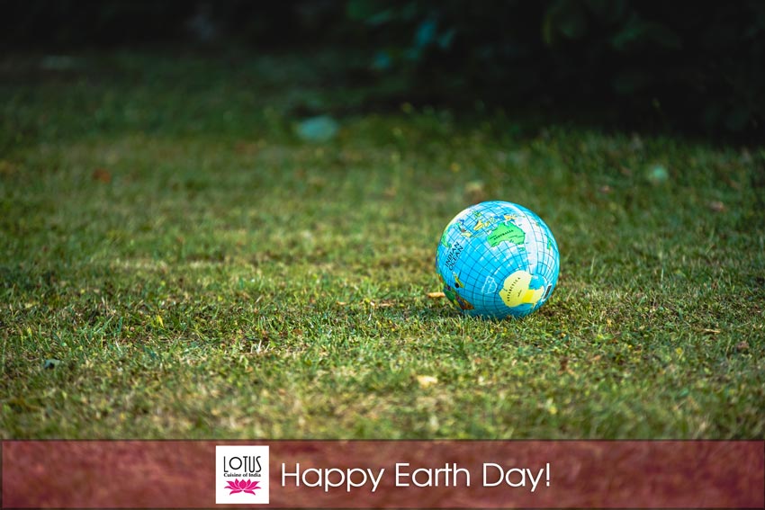 Lotus Cuisine of India - Happy Earth Day - Globe on grass, logo and texts.
